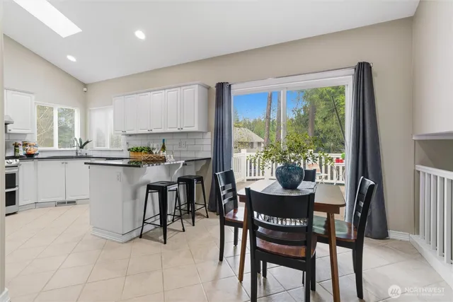 a dining room with kitchen island furniture a large window and kitchen view