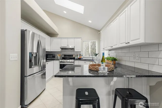 a kitchen with white cabinets and stainless steel appliances