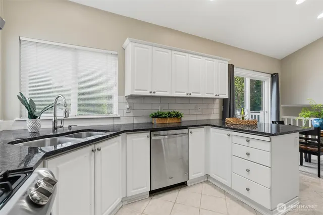 a kitchen with granite countertop white cabinets white appliances and a sink