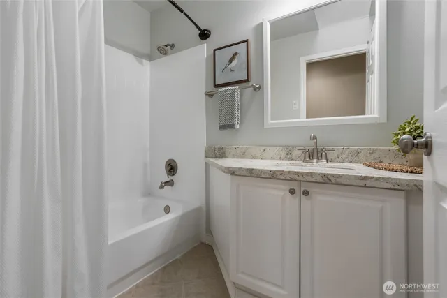 a bathroom with a granite countertop sink mirror and a bathtub