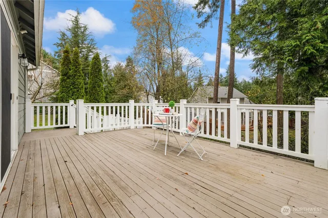 a view of deck with wooden floor and fence with a large tree