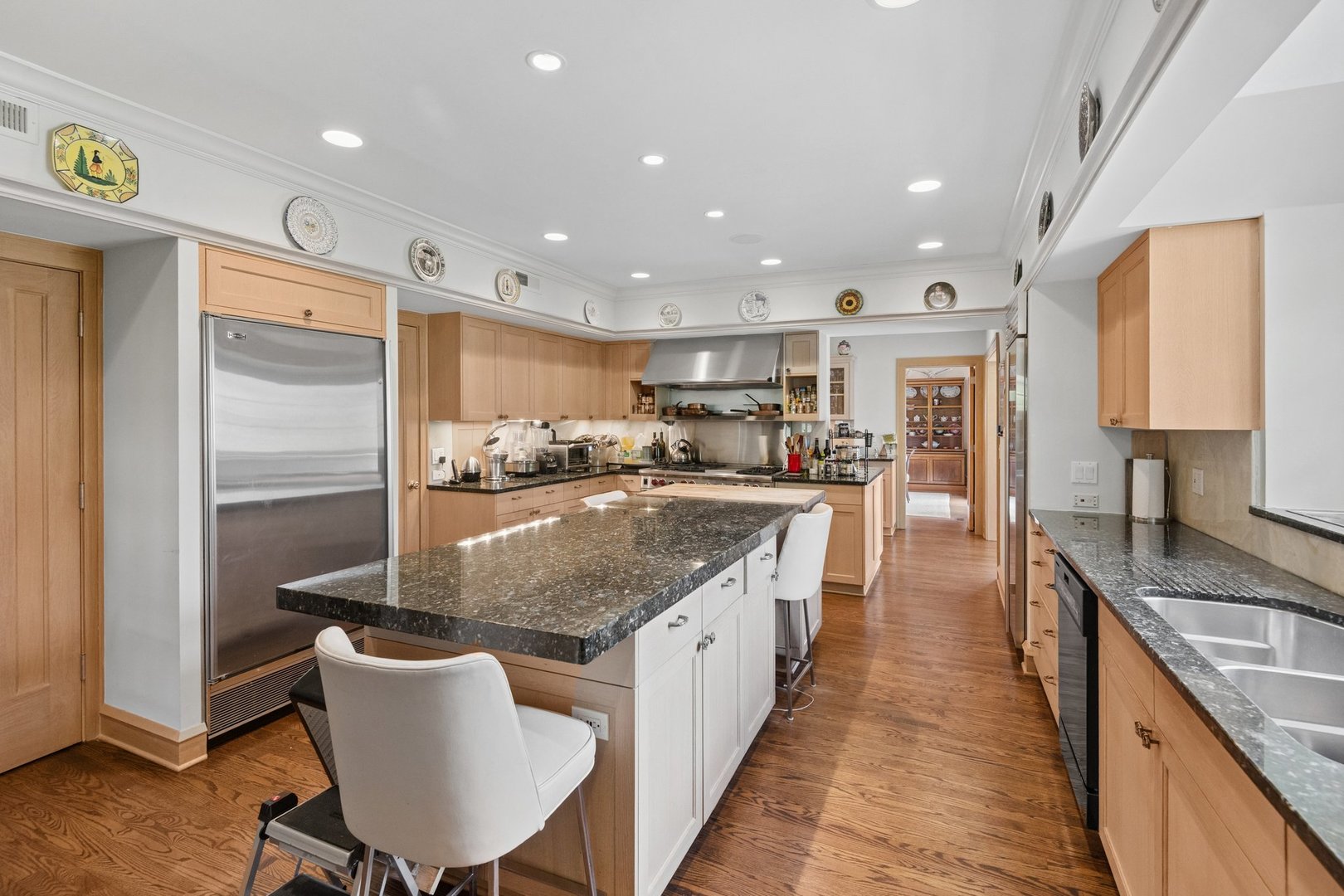 321 Woodland Road Highland Park, IL 60035 - Photo 15 of 48 a large kitchen with kitchen island a large counter top space a sink stainless steel appliances and cabinets