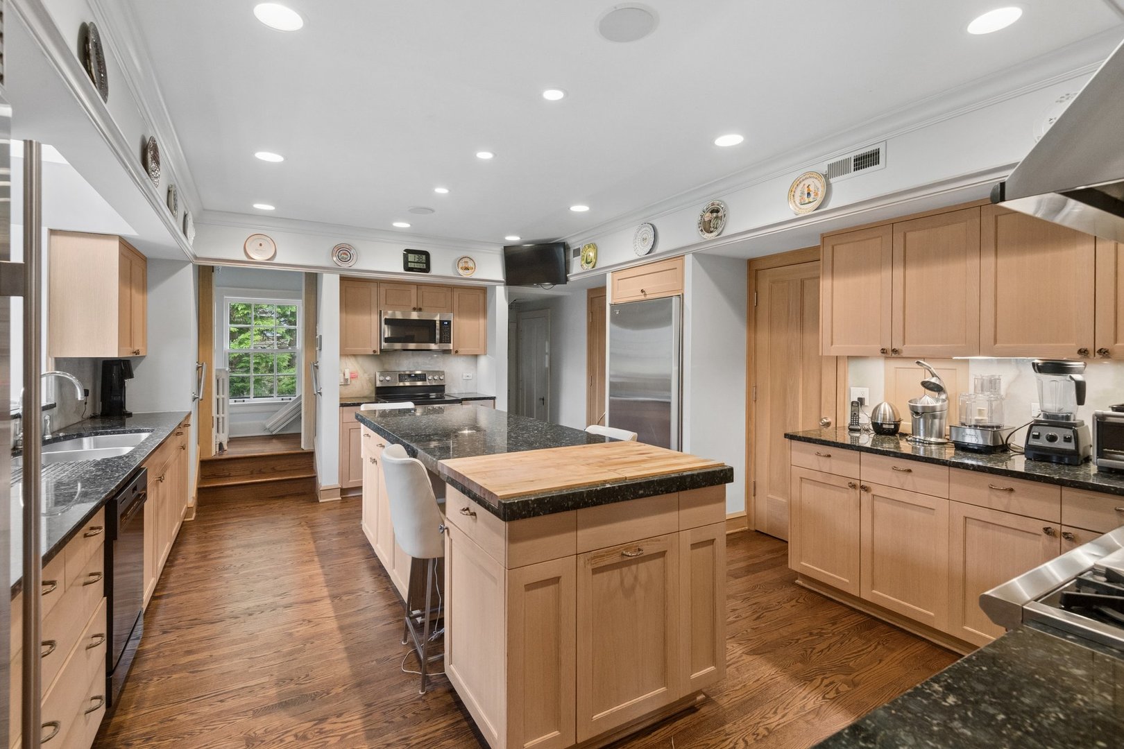 321 Woodland Road Highland Park, IL 60035 - Photo 18 of 48 a kitchen with kitchen island granite countertop lots of counter top space a sink stainless steel appliances and cabinets