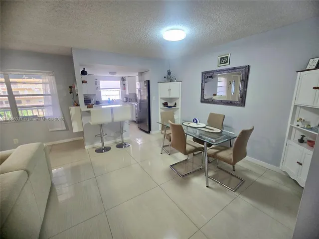 a work room with furniture a rug and a window