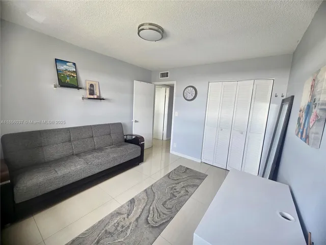 a living room with a couch and a refrigerator