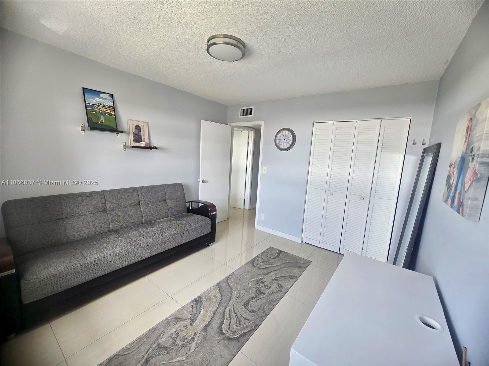 5300 Washington Street, Unit U403 Hollywood, FL 33021 - Photo 8 of 12 a living room with a couch and a refrigerator