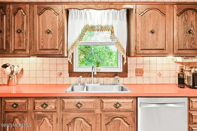 a kitchen with granite countertop a stove sink and cabinets