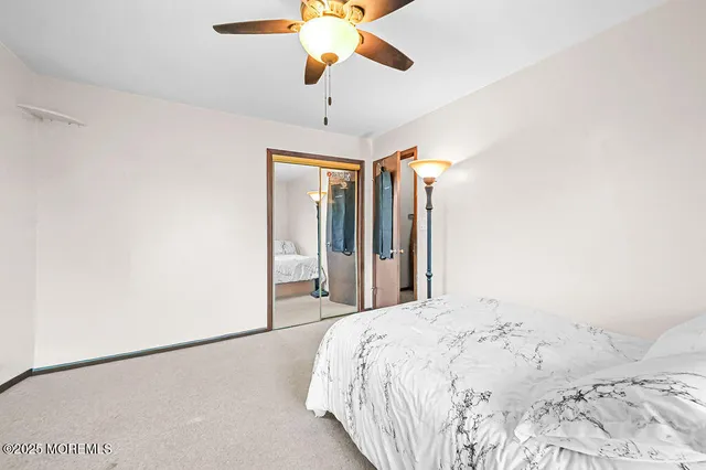 a bedroom with a bed and a flat tv screen on dresser