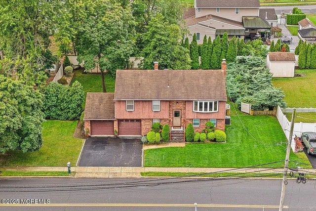 an aerial view of a house with a garden and large trees
