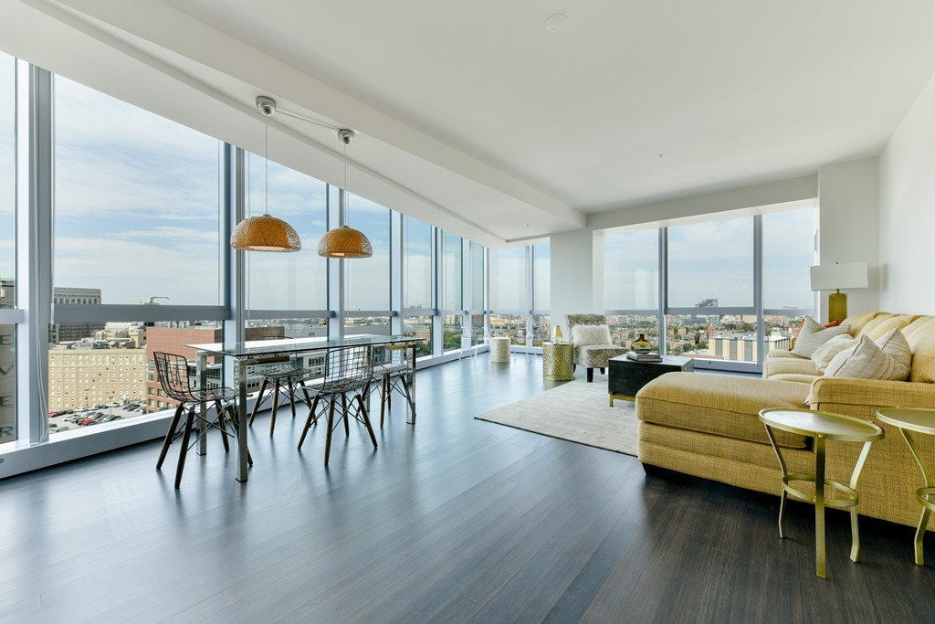 a living room with furniture a wooden floor and next to a window