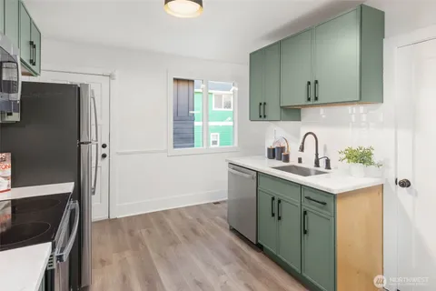 a kitchen with stainless steel appliances a stove microwave and sink