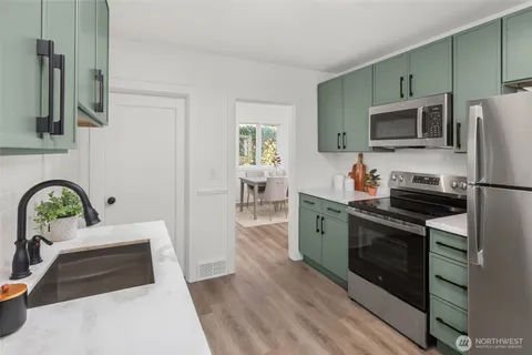 a kitchen with stainless steel appliances granite countertop a sink and a white cabinets