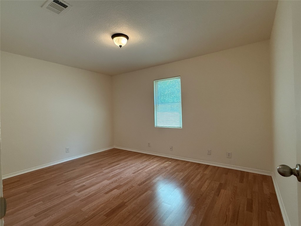 314 Raintree Drive Georgetown, TX 78626 - Photo 5 of 13 an empty room with wooden floor and windows