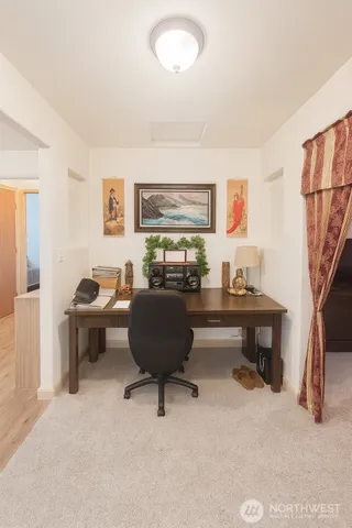 a view of a workspace with furniture and a window