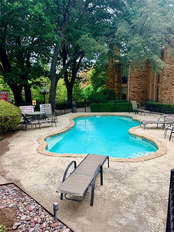 14333 Preston Road, Unit 806 Dallas, TX 75254 - Photo 3 of 17 Freeform outdoor pool with stone coping, surrounded by a concrete patio and mature trees