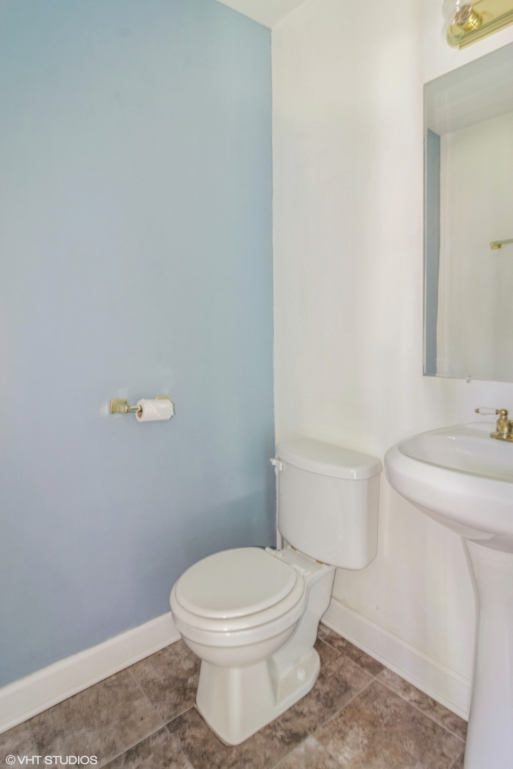 905 Thomas Avenue, Unit 1 Forest Park, IL 60130 - Photo 12 of 15 a white toilet sitting next to a white sink and vanity