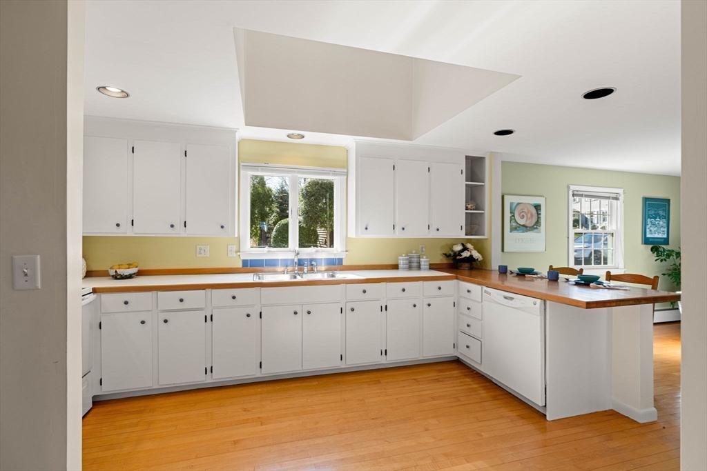 153 Jersey Street Marblehead, MA 01945 - Photo 10 of 34 a large white kitchen with granite countertop a sink and dishwasher a stove with wooden floors