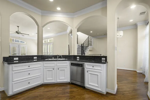 a large white kitchen with granite countertop a stove a sink and a refrigerator