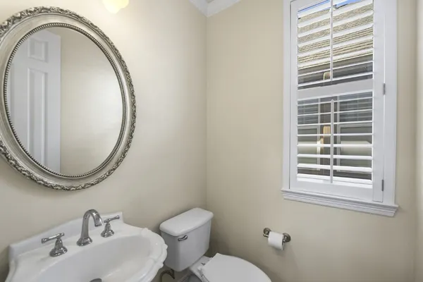 a bathroom with a sink mirror and toilet