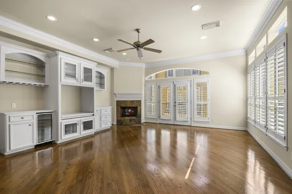 a view of an empty room with a kitchen and a window