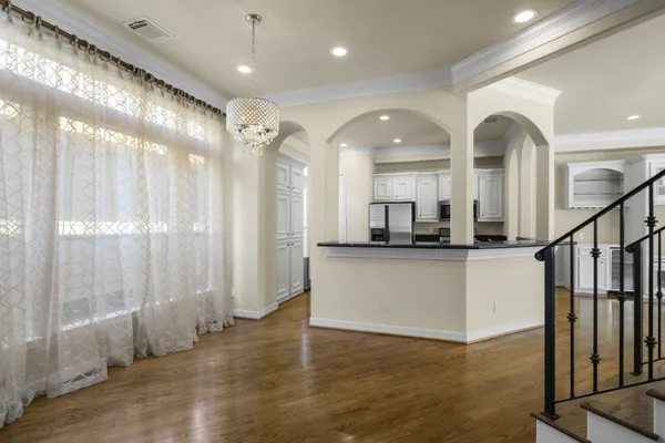 a view of a big room with wooden floor and windows
