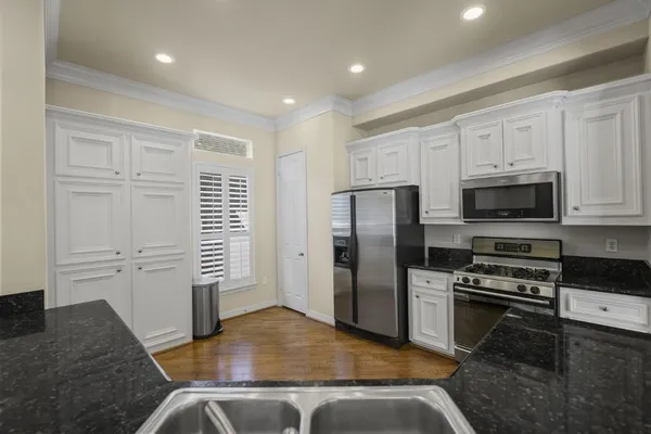 a kitchen with stainless steel appliances granite countertop a refrigerator a stove and a sink