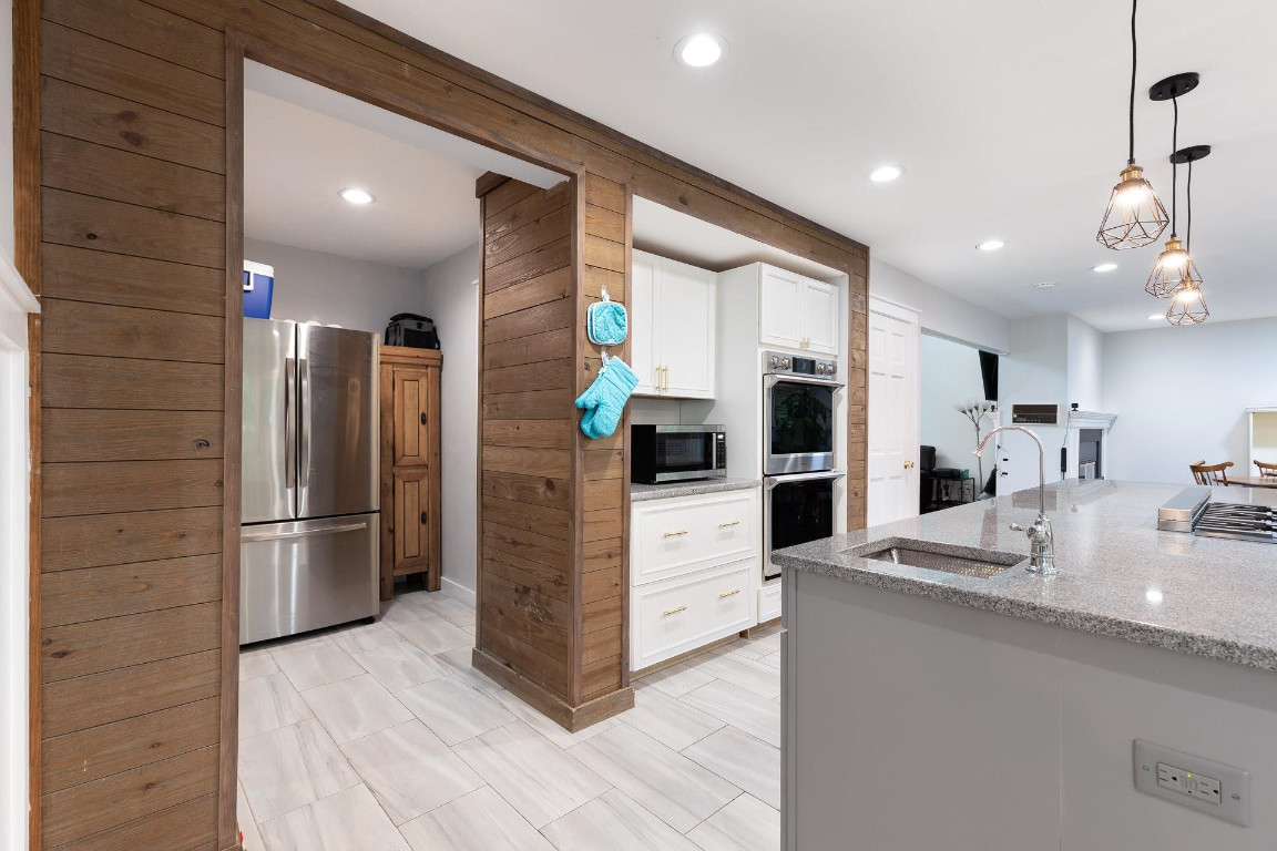 5006 Greenview Drive Durham, NC 27713 - Photo 11 of 34 a kitchen with stainless steel appliances kitchen island granite countertop a refrigerator and a sink