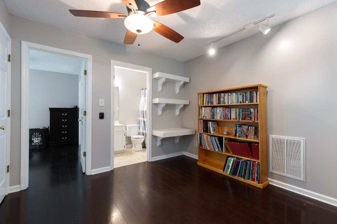 5006 Greenview Drive Durham, NC 27713 - Photo 25 of 34 a view of a livingroom with a bookshelf and wooden floor