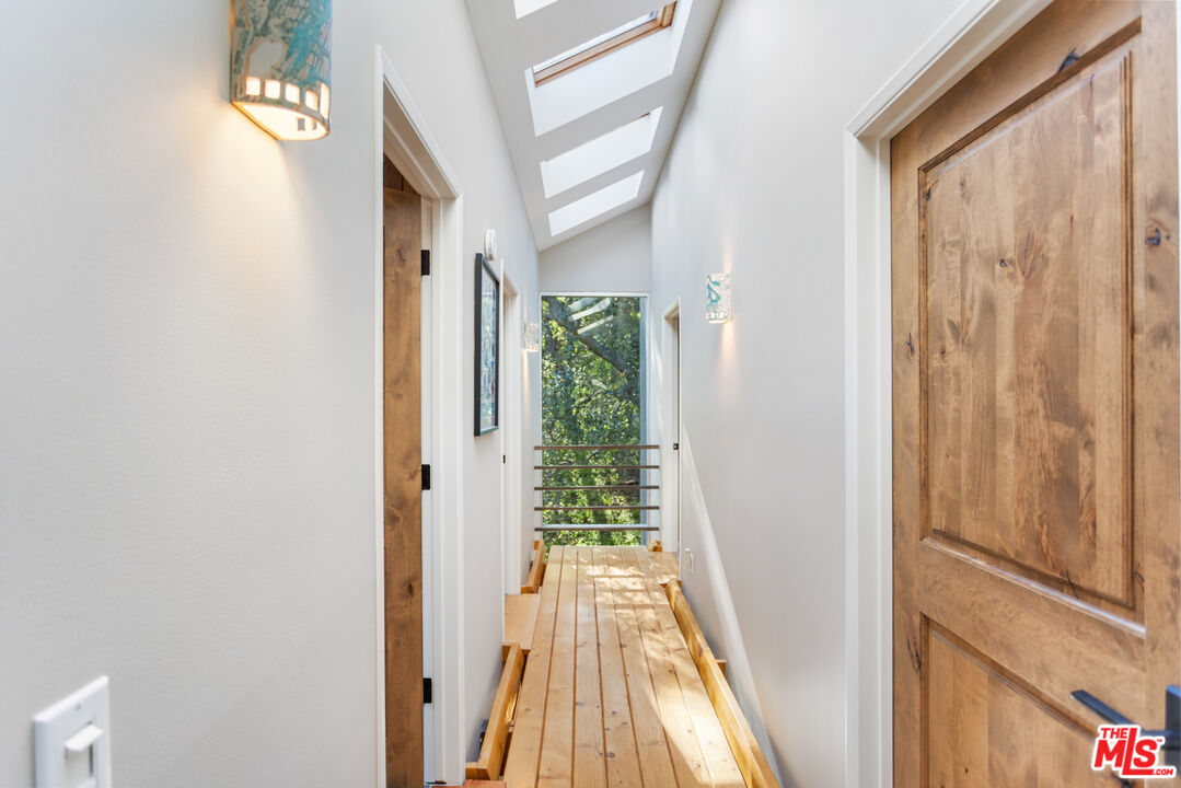 3217 Canon Place Topanga, CA 90290 - Photo 19 of 49 a view of a hallway with wooden floor and furniture