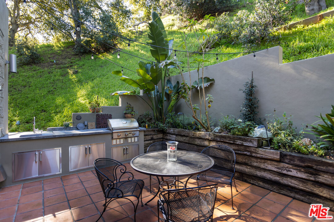 3217 Canon Place Topanga, CA 90290 - Photo 6 of 49 a backyard of a house with table and chairs plants and large tree