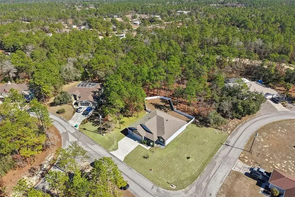 an aerial view of a house with a yard and trees