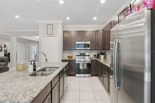 a kitchen with kitchen island granite countertop a sink stainless steel appliances and cabinets
