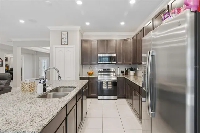 a kitchen with kitchen island granite countertop a sink stainless steel appliances and cabinets