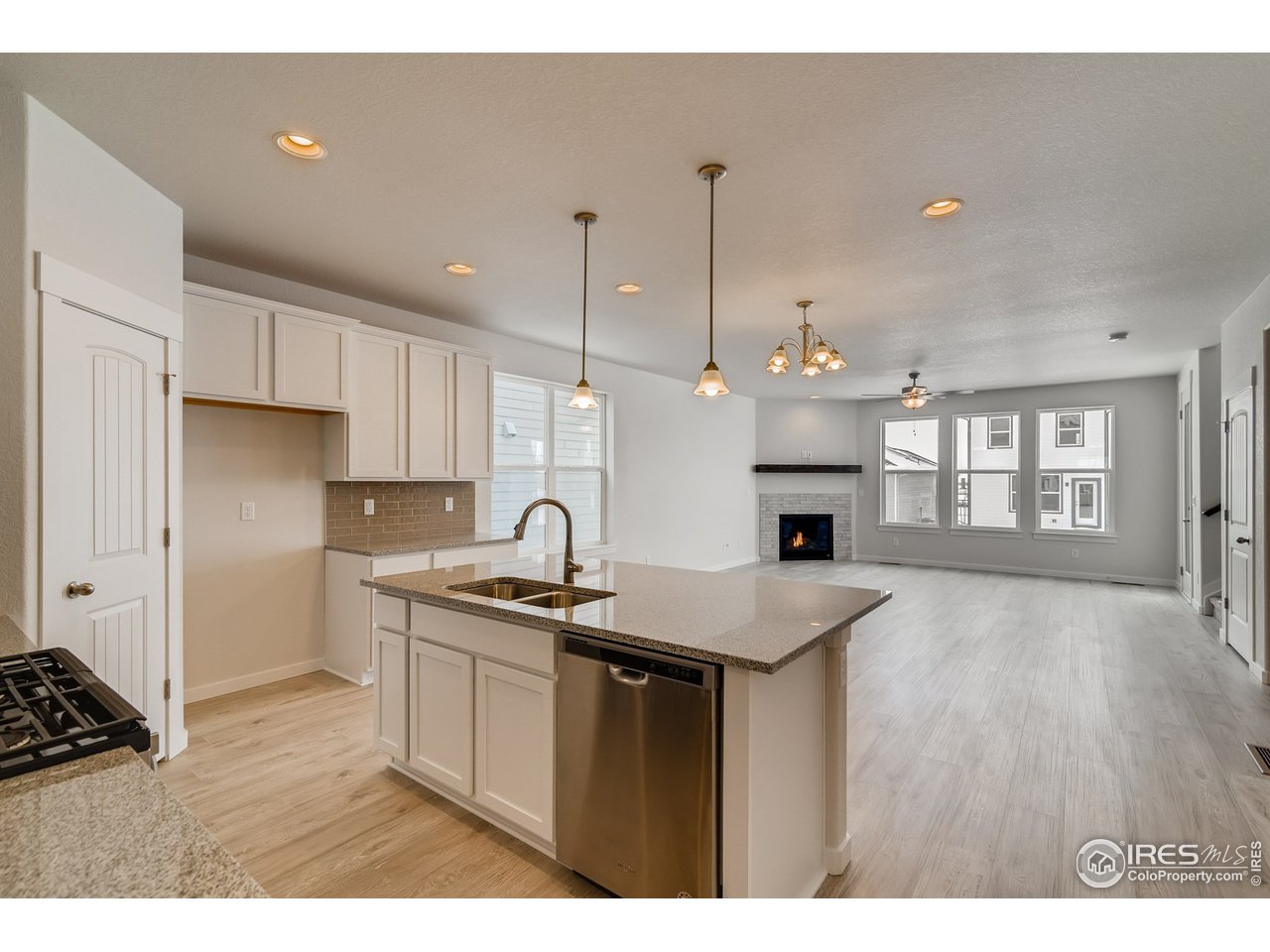2147 Gather Drive Windsor, CO 80550 - Photo 13 of 28 a kitchen with a sink a stove a refrigerator and a fireplace