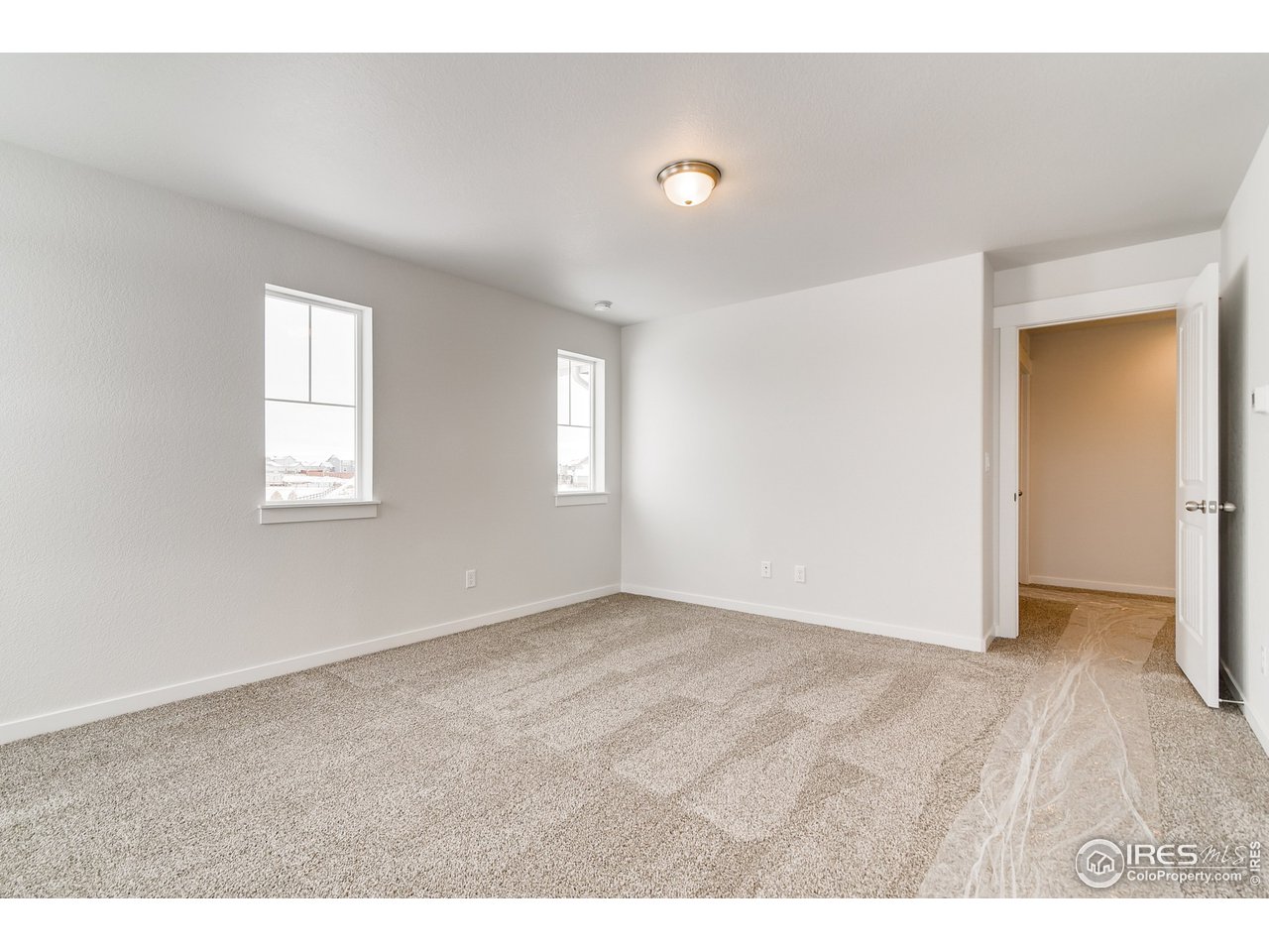 2147 Gather Drive Windsor, CO 80550 - Photo 17 of 28 a view of an empty room with wooden floor and a window