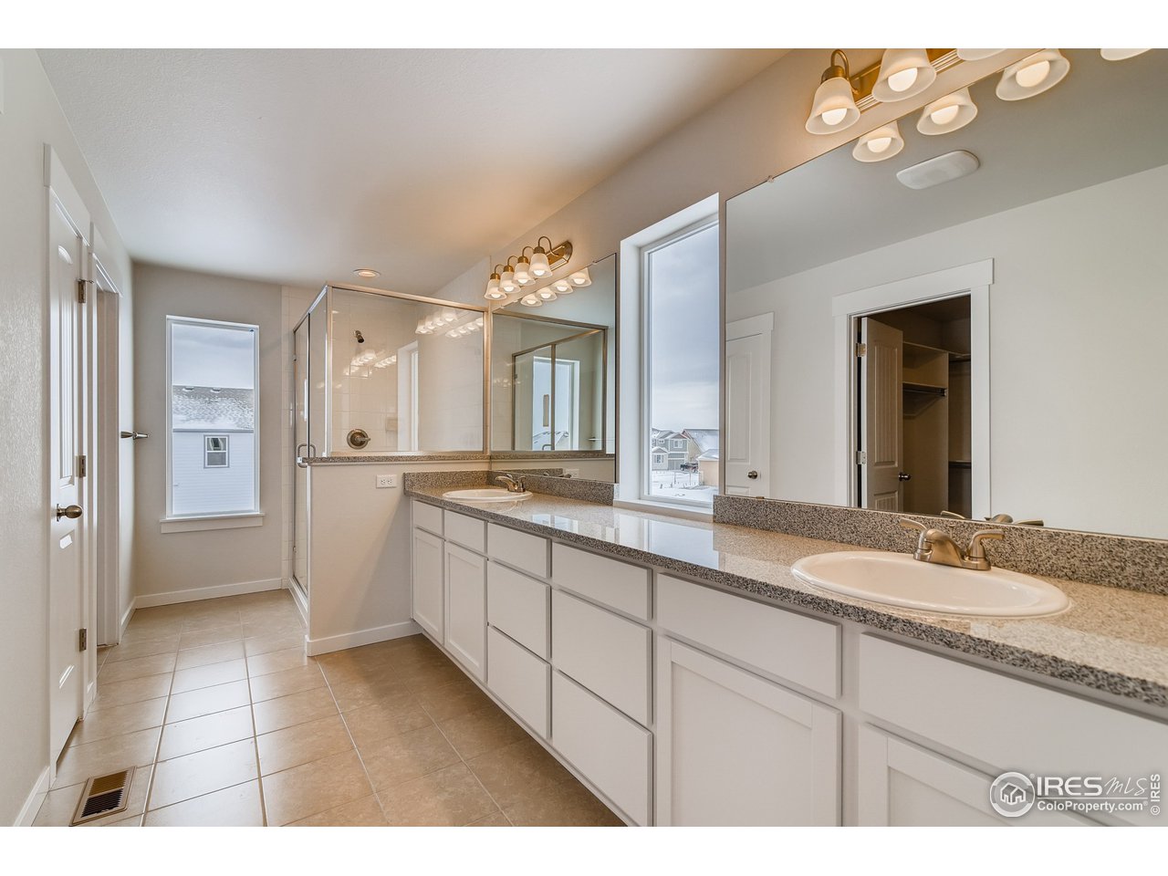 2147 Gather Drive Windsor, CO 80550 - Photo 18 of 28 a spacious bathroom with a granite countertop sink mirror and shower