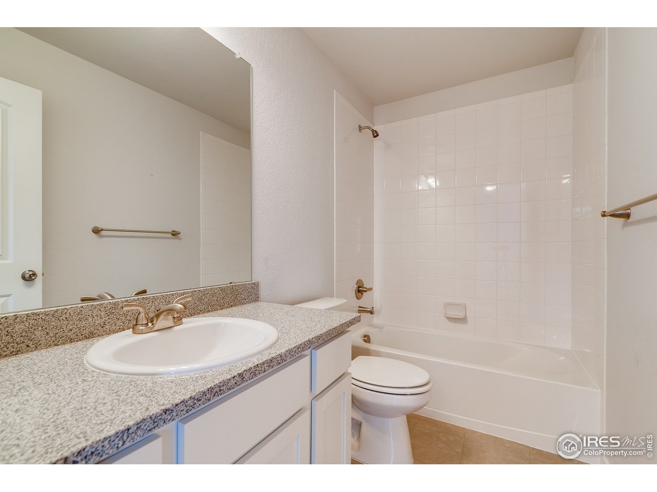 2147 Gather Drive Windsor, CO 80550 - Photo 24 of 28 a bathroom with a granite countertop sink a toilet a mirror and shower