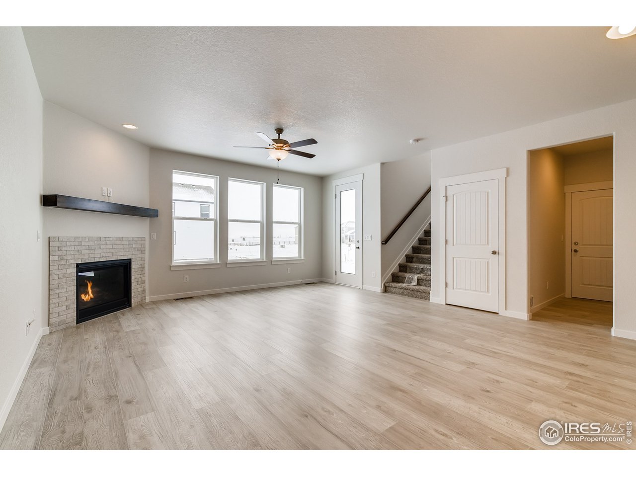 2147 Gather Drive Windsor, CO 80550 - Photo 7 of 28 a view of an empty room with wooden floor fireplace and a window