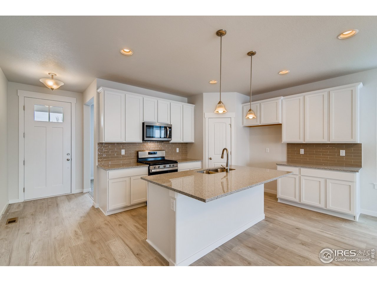 2147 Gather Drive Windsor, CO 80550 - Photo 10 of 28 a kitchen with stainless steel appliances granite countertop a sink refrigerator and cabinets