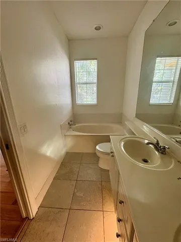a bathroom with a granite countertop toilet a sink and a bathtub