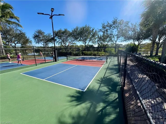 a view of a tennis ground with large trees