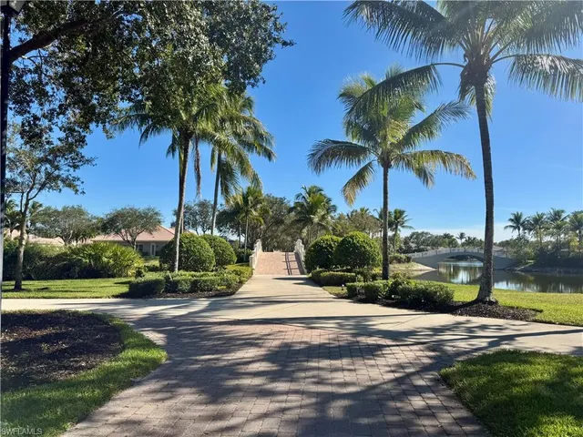 a front view of a house with a yard and palm trees
