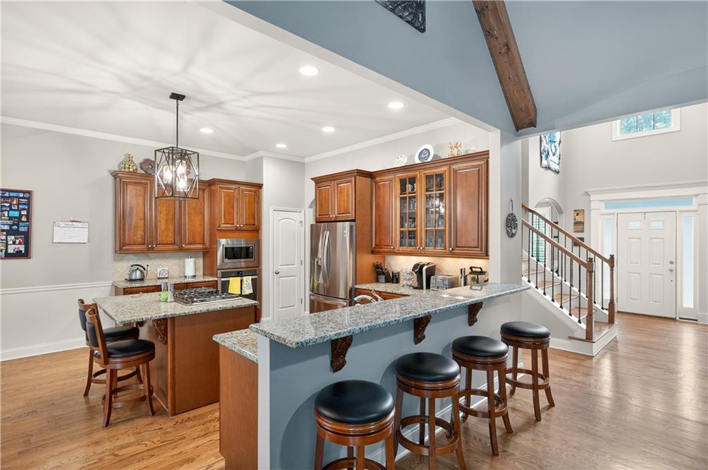5250 Kendalls Way Cumming, GA 30041 - Photo 11 of 42 a dining hall with stainless steel appliances kitchen island granite countertop a dining table chairs and a refrigerator