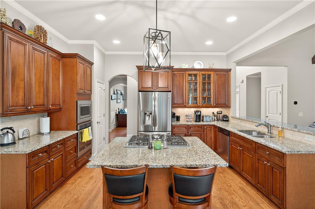 5250 Kendalls Way Cumming, GA 30041 - Photo 12 of 42 a kitchen with stainless steel appliances granite countertop a sink refrigerator and cabinets