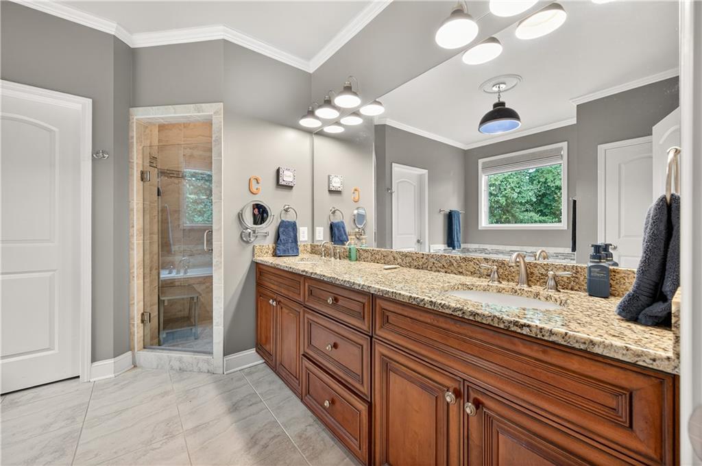 5250 Kendalls Way Cumming, GA 30041 - Photo 18 of 42 a bathroom with a granite countertop sink a large mirror and a shower