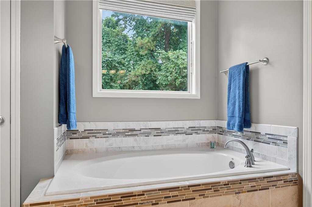 5250 Kendalls Way Cumming, GA 30041 - Photo 19 of 42 a bathroom with a bathtub and window