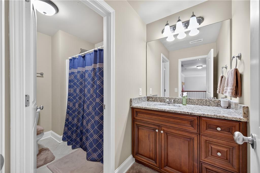 5250 Kendalls Way Cumming, GA 30041 - Photo 26 of 42 a bathroom with a granite countertop sink a mirror a vanity and a shower