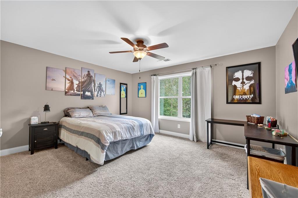 5250 Kendalls Way Cumming, GA 30041 - Photo 27 of 42 a spacious bedroom with a bed and a chandelier