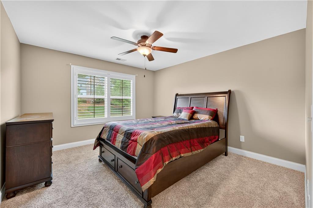 5250 Kendalls Way Cumming, GA 30041 - Photo 28 of 42 a bedroom with a bed and a chandelier