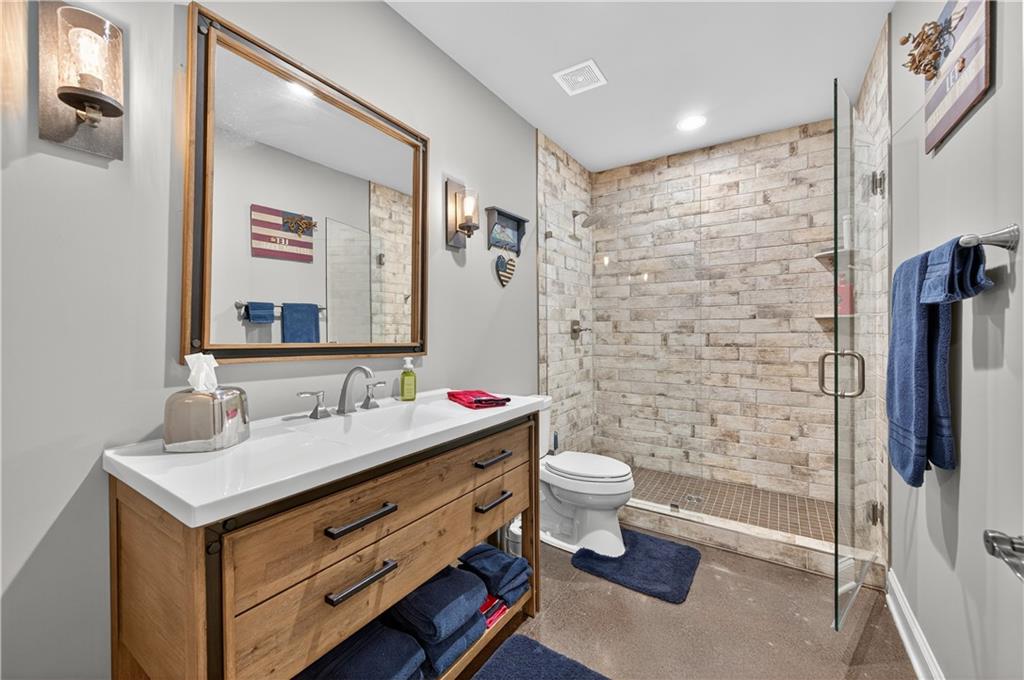 5250 Kendalls Way Cumming, GA 30041 - Photo 34 of 42 a bathroom with a sink toilet a mirror and shower